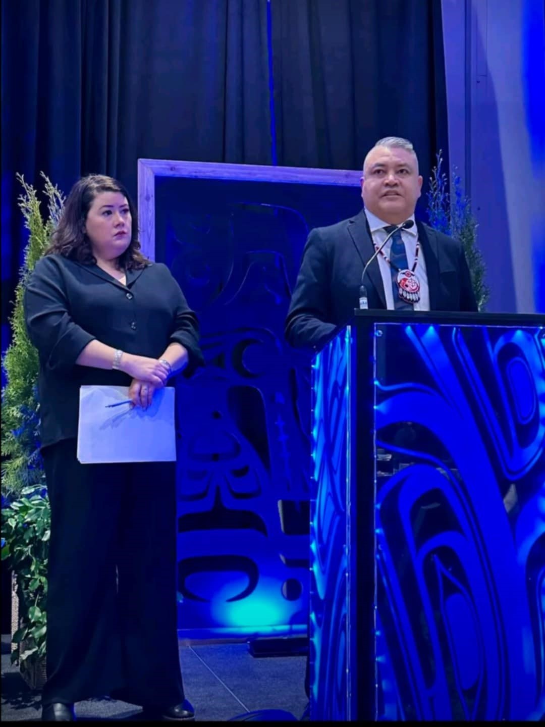 Regional Chief Terry Teegee speaking at an illuminated podium