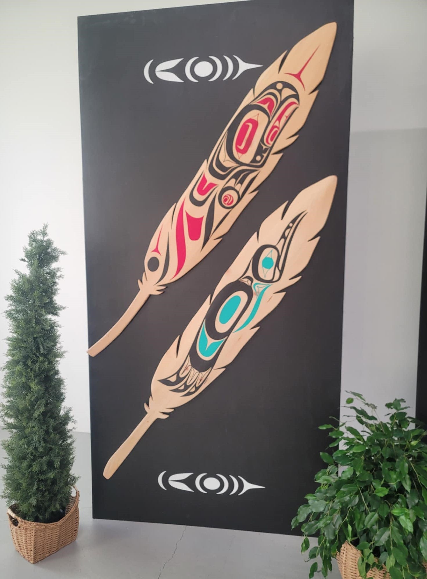 Black display panel with wooden Indigenous feather designs